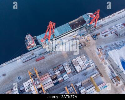 Le port commercial nord de l'arctique charge des conteneurs sur un navire-citerne. Logistique de concept et livraison de marchandises Banque D'Images