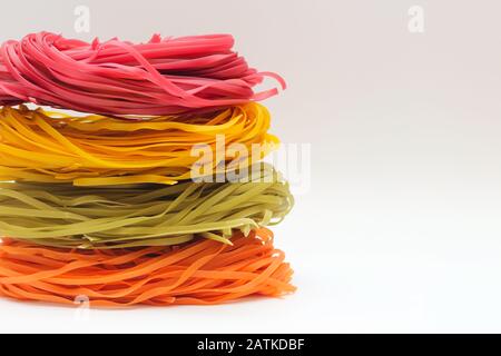 Les spaghettis colorés isolés se niche sur un fond blanc. Banque D'Images