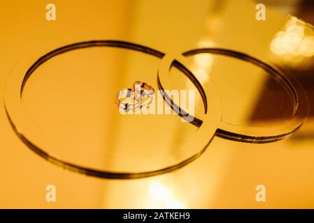 Anneaux de mariage sur un stand dans des tons d'or. Banque D'Images