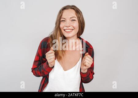 Freestyle. Jeune femme avec des cornichons debout isolé sur des mains grises dans le poing gai Banque D'Images