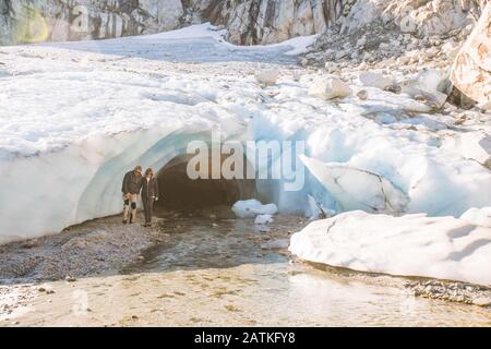 Un couple à la retraite émerge de la grotte de glace glaciaire lors d'une visite de luxe. Banque D'Images