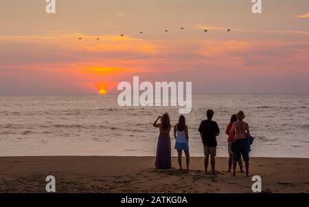 Les gens qui regardent le coucher du soleil sur la plage de San Francisco (San Francisco), Nayarit, Mexique. Banque D'Images