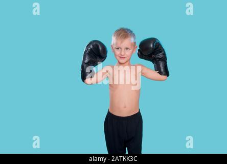 Joyeux petit enfant avec des gants de boxe noirs Banque D'Images