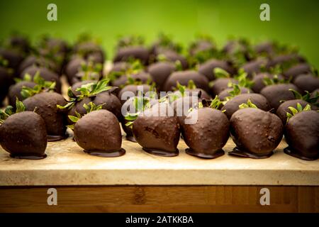 Grand groupe de fraises enrobées de chocolat noir à la fête Banque D'Images