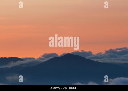 Coucher de soleil avec ciel coloré et de nombreux nuages au-dessus des montagnes Banque D'Images