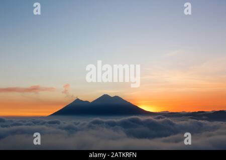 Coucher de soleil sur le volcan du feu et le volcan Acatenango - volcans entourés de nuages Banque D'Images