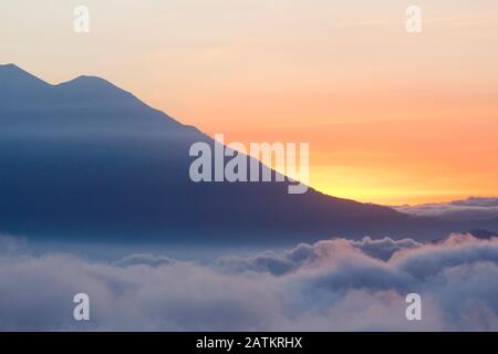 Coucher de soleil avec ciel coloré et de nombreux nuages au-dessus des montagnes du Guatemala Banque D'Images