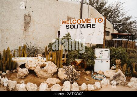 Loque de voiture et signe de bienvenue dans le désert de sable de Solitaire Namibie Banque D'Images