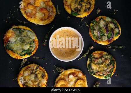 Petite mini pizza. Ensemble de mini pizzas différentes. Pizza : aux crevettes, aux champignons, aux épinards et aux oignons, au bacon, au patroni et aux tomates Banque D'Images