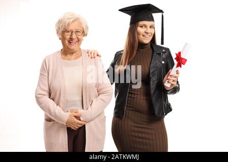 Jeune femme avec un chapeau de graduation et un diplôme posant avec une dame âgée isolée sur fond blanc Banque D'Images