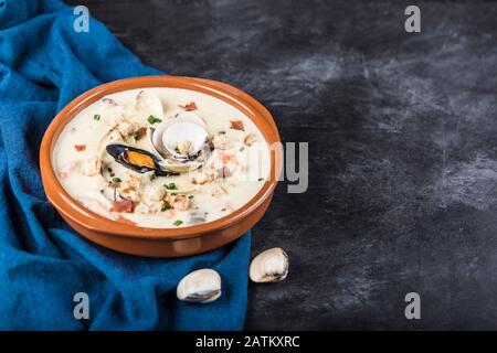 Chaudrée de palourdes dans une plaque marron. Les principaux ingrédients sont les mollusques, le bouillon, le beurre, les pommes de terre et les oignons. Soupe de la Nouvelle-Angleterre également connue sous le nom de Boston clam chow Banque D'Images