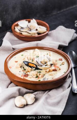 Chaudrée de palourdes dans une plaque marron. Les principaux ingrédients sont les mollusques, le bouillon, le beurre, les pommes de terre et les oignons. Soupe de la Nouvelle-Angleterre également connue sous le nom de Boston clam chow Banque D'Images