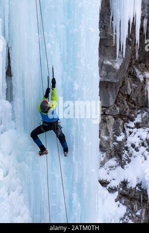 Grimpeur de glace sur les chutes supérieures gelées du Canyon Johnston, dans le parc national Banff, en Alberta, au Canada Banque D'Images