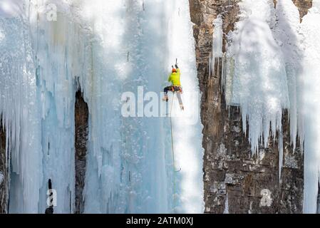 Grimpeur de glace sur les chutes supérieures gelées du Canyon Johnston, dans le parc national Banff, en Alberta, au Canada Banque D'Images