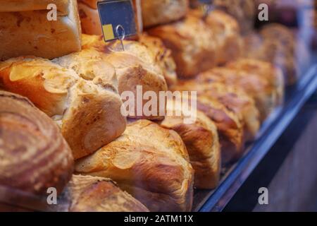 Vitrine du magasin avec tas et pile de pains de blé et de seigle de raisins secs avec repas de grain entier et croûte de moutarde rustique à l'avant de la boulangerie. Banque D'Images