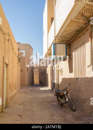 Deux motos se trouvant dans une rue typique de la vieille ville de Yazd, en iran, avec ses murs et bâtiments en argile typiques. Yazd est la ville principale de Central Banque D'Images