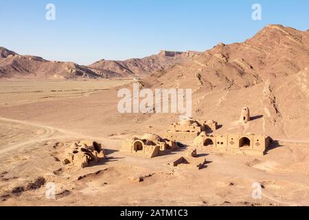 Vieux village iranien abandonnés dans le désert près de la ville de Yazd, fait d'argile murs et maisons d'argile, à moitié détruit, entouré par rocky mountain hi Banque D'Images