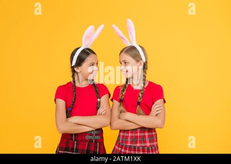 Jeux traditionnels de Pâques. Équipe de Bunny. Concept de divertissement et d'événement. Vacances de printemps. Enfants dans les oreilles de lapin de lapin. Famille et Sisterhood. Uniforme scolaire pour petites écolières avec de longues oreilles de lapin. Banque D'Images