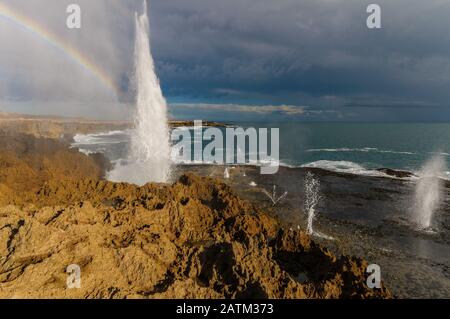 Un océan Indien rugueux livre les falaises accidentées de Woroorra Station en Australie occidentale, provoquant de nombreux trous de fuite d'eau de mer dans le ciel . Banque D'Images