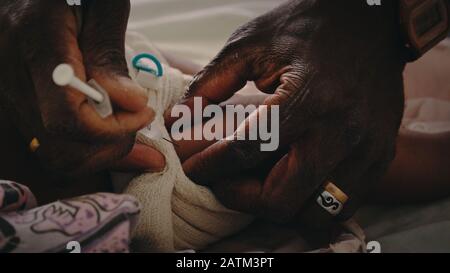 Melsisi, île de la Pentecôte / Vanuatu - 10 MAI 2019: Mignon jeune enfant du pacifique noir se faire vacciner injecté lors d'un contrôle médical par une infirmière à Banque D'Images