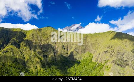 Vue d'en haut, vue imprenable aérienne d'une chaîne de montagnes verdoyante entourée de nuages et d'un beau ciel bleu en arrière-plan. Sembalun, Lombok. Banque D'Images