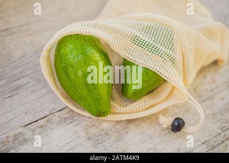 Avocat dans un sac réutilisable sur une élégante surface de cuisine en bois. Concept zéro déchet Banque D'Images