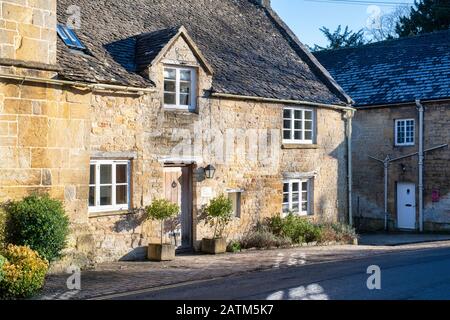 Cotswold pierre cottages en hiver lumière du soleil. Withington, Gloucestershire, Angleterre Banque D'Images