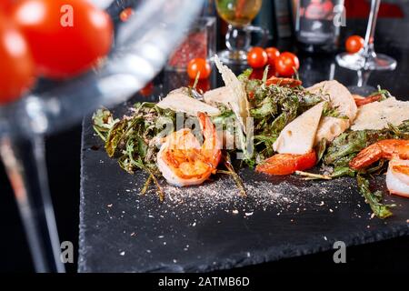 Délicieux plat avec crevettes grillées, calmars, croûtons et salade d'arugula et crevettes frites épicées. Menu du restaurant, concept de nourriture naturelle et biologique. Banque D'Images