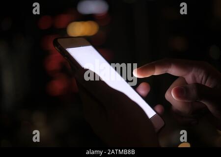 Gros plan sur les femmes utilisent le smartphone la nuit Banque D'Images