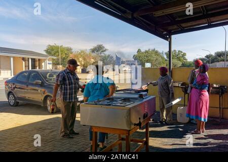 Rehoboth, Namibie/Afrique - 27 mai 2017: [Couple plus âgé attendant leur commande à emporter dans un stand de restauration barbecue de rue, les propriétaires riant.] Banque D'Images