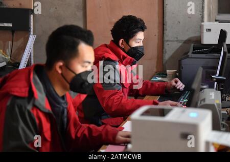 (200204) -- XI'AN, 4 février 2020 (Xinhua) -- Xu Guobin (R) contrôle l'inventaire à Xi'an, dans le nord-ouest de la province de Shaanxi en Chine, 3 février 2020. Le livreur Xu Guobin a continué à travailler pendant les vacances du Festival du printemps pendant 12 jours. Influencé par le déclenchement de nouveaux coronavirus, Xu doit livrer des colis trois fois plus que les dernières années. Lorsqu'on lui a demandé s'il s'inquiétait d'être infecté, Xu a répondu en disant que bien qu'il ait eu une telle préoccupation, ce qu'il pouvait faire était de bien se protéger tout en livrant des colis aux personnes qui en avaient besoin. (Xinhua/Liu Xiao) Banque D'Images