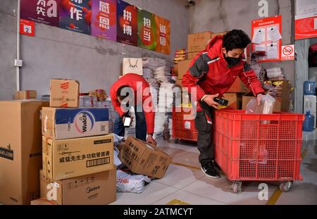 (200204) -- XI'AN, 4 février 2020 (Xinhua) -- Xu Guobin et son collègue enregistrent des paquets à Xi'an, dans la province du Shaanxi, dans le nord-ouest de la Chine, 3 février 2020. Le livreur Xu Guobin a continué à travailler pendant les vacances du Festival du printemps pendant 12 jours. Influencé par le déclenchement de nouveaux coronavirus, Xu doit livrer des colis trois fois plus que les dernières années. Lorsqu'on lui a demandé s'il s'inquiétait d'être infecté, Xu a répondu en disant que bien qu'il ait eu une telle préoccupation, ce qu'il pouvait faire était de bien se protéger tout en livrant des colis aux personnes qui en avaient besoin. (Xinhua/Liu Xiao) Banque D'Images