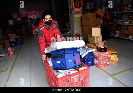 (200204) -- XI'AN, 4 février 2020 (Xinhua) -- Xu Guobin porte son paquet à Xi'an, dans le nord-ouest de la province de Shaanxi en Chine, 3 février 2020. Le livreur Xu Guobin a continué à travailler pendant les vacances du Festival du printemps pendant 12 jours. Influencé par le déclenchement de nouveaux coronavirus, Xu doit livrer des colis trois fois plus que les dernières années. Lorsqu'on lui a demandé s'il s'inquiétait d'être infecté, Xu a répondu en disant que bien qu'il ait eu une telle préoccupation, ce qu'il pouvait faire était de bien se protéger tout en livrant des colis aux personnes qui en avaient besoin. (Xinhua/Liu Xiao) Banque D'Images