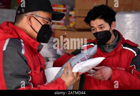 (200204) -- XI'AN, 4 février 2020 (Xinhua) -- Xu Guobin (R) se prépare à être livré à Xi'an, dans le nord-ouest de la province de Shaanxi, 3 février 2020. Le livreur Xu Guobin a continué à travailler pendant les vacances du Festival du printemps pendant 12 jours. Influencé par le déclenchement de nouveaux coronavirus, Xu doit livrer des colis trois fois plus que les dernières années. Lorsqu'on lui a demandé s'il s'inquiétait d'être infecté, Xu a répondu en disant que bien qu'il ait eu une telle préoccupation, ce qu'il pouvait faire était de bien se protéger tout en livrant des colis aux personnes qui en avaient besoin. (Xinhua/Liu Xiao) Banque D'Images