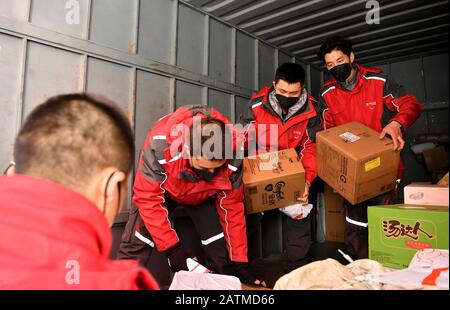 (200204) -- XI'AN, 4 février 2020 (Xinhua) -- Xu Guobin (R) et ses collègues ont des paquets à Xi'an, dans le nord-ouest de la province de Shaanxi, 3 février 2020. Le livreur Xu Guobin a continué à travailler pendant les vacances du Festival du printemps pendant 12 jours. Influencé par le déclenchement de nouveaux coronavirus, Xu doit livrer des colis trois fois plus que les dernières années. Lorsqu'on lui a demandé s'il s'inquiétait d'être infecté, Xu a répondu en disant que bien qu'il ait eu une telle préoccupation, ce qu'il pouvait faire était de bien se protéger tout en livrant des colis aux personnes qui en avaient besoin. (Xinhua/Liu Xiao) Banque D'Images