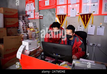 (200204) -- XI'AN, 4 février 2020 (Xinhua) -- Xu Guobin (l') vérifie ses commandes à Xi'an, dans le nord-ouest de la province de Shaanxi en Chine, 3 février 2020. Le livreur Xu Guobin a continué à travailler pendant les vacances du Festival du printemps pendant 12 jours. Influencé par le déclenchement de nouveaux coronavirus, Xu doit livrer des colis trois fois plus que les dernières années. Lorsqu'on lui a demandé s'il s'inquiétait d'être infecté, Xu a répondu en disant que bien qu'il ait eu une telle préoccupation, ce qu'il pouvait faire était de bien se protéger tout en livrant des colis aux personnes qui en avaient besoin. (Xinhua/Liu Xiao) Banque D'Images