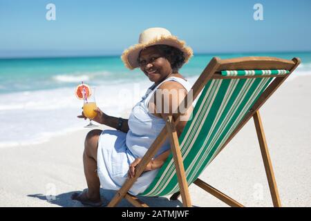 Vieille femme se reposant sur la plage Banque D'Images