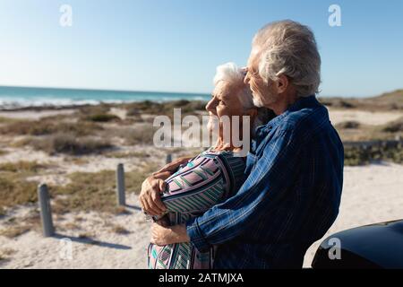 Un vieux couple avec une voiture à la plage Banque D'Images