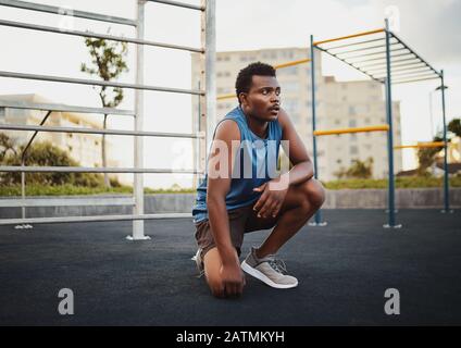 Portrait de jeune homme sportif africain américain se détendre à l'extérieur après une séance d'entraînement dans le parc de salle de sport public Banque D'Images