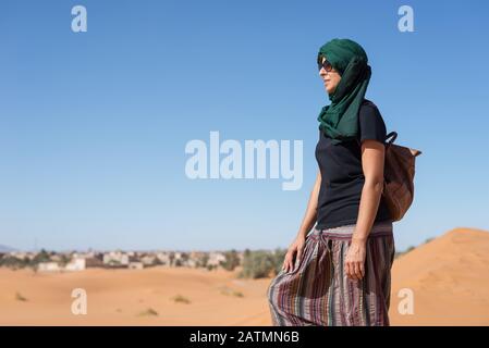 Femme regardant les dunes d'horizon dans le désert marocain du Sahara. Banque D'Images