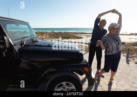 Un vieux couple avec une voiture à la plage Banque D'Images