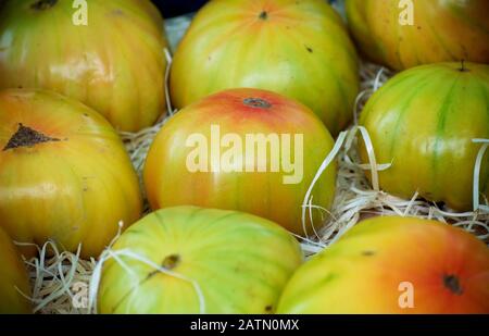 Tomates jaunes et vertes à rayures dans une boîte à un marché aux légumes de saison en automne Banque D'Images