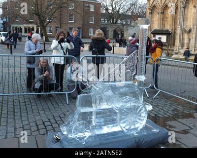 Les gens qui consultent une sculpture de glace complexe sous la forme d'un train à vapeur Rocket de Stephenson à l'extérieur de York Minster à la York Ice Trail 2020 Banque D'Images