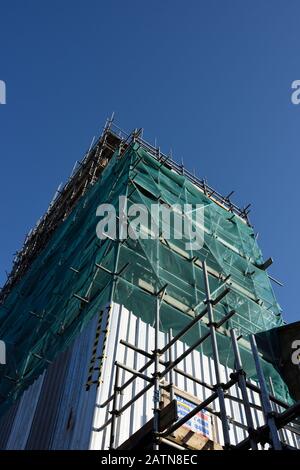 Filets de débris verts couvrant l'échafaudage sur la tour de l'église St maries pendant les travaux de restauration et de réparation avec le ciel bleu à l'enterrement lancashire royaume-uni Banque D'Images