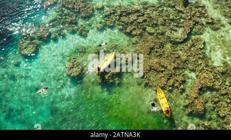 Les touristes sur le kayak dans le lagon à l'eau claire, vue aérienne. La plongée avec tuba et le kayak dans le lagon. Petite lagune aux eaux turquoises. El Nido, Palawan, Philippines. Billet d'été et vacances. Banque D'Images