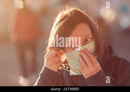 Femme avec masque de protection du visage debout dans la rue, protection contre les épidémies infections respiratoires de virus Banque D'Images