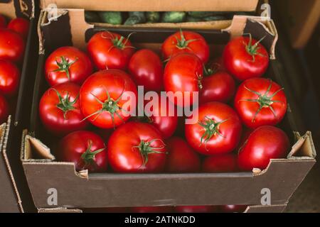 Tomates mûres fraîches emballées dans une boîte en carton sur le marché de la rue ou greengrocery, vue de dessus Banque D'Images