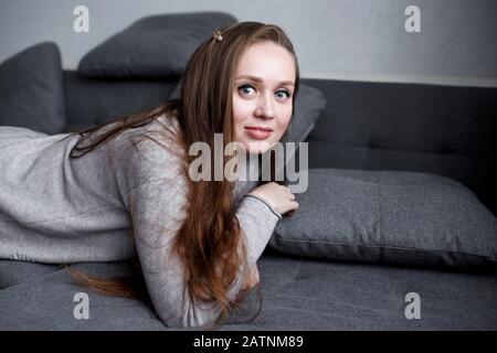 Portrait étroit de jeune femme auto-assurée dans un intérieur gris maison, style hugge, moderne et tendance belle femme Banque D'Images