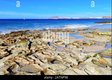 Vue sur la belle plage de Papagayo, mer bleue, sable jaune, falaises. Playa Blanca ville, Lanzarote, îles Canaries, point de mire sélectif Banque D'Images