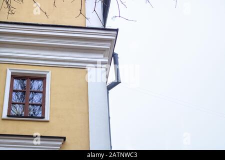 Fenêtres de style rétro et drainpipe sur un mur jaune Banque D'Images